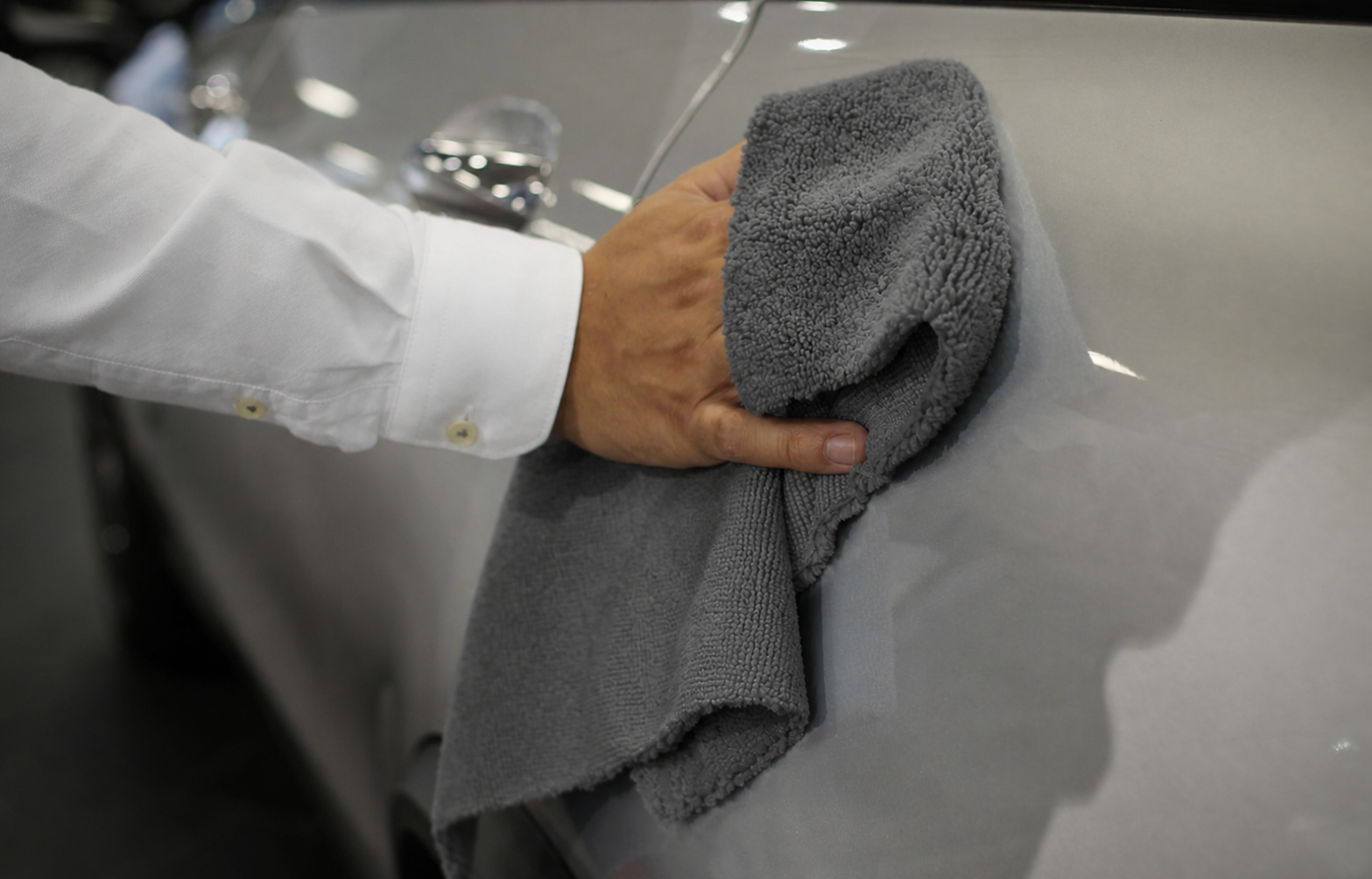 Graues High-Low Mikrofasertuch bei der Lackpflege eines Fahrzeugs